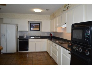 Large eat in kitchen with saltillo tile, tons of cabinets and pl